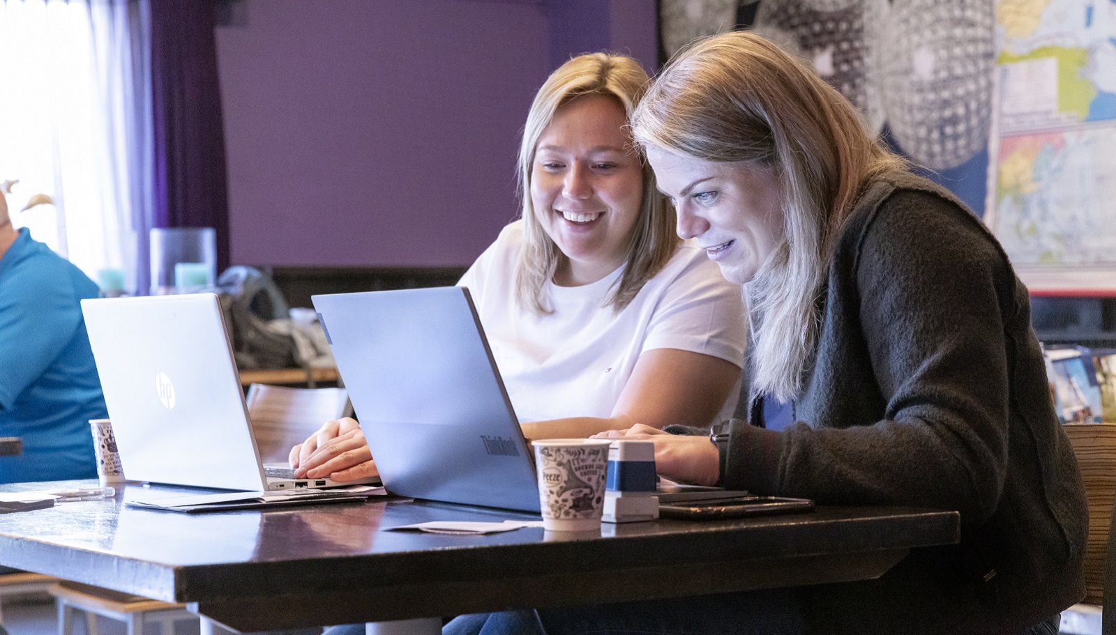 Twee vrijwilligers Exodus Wandeltocht achter de laptop