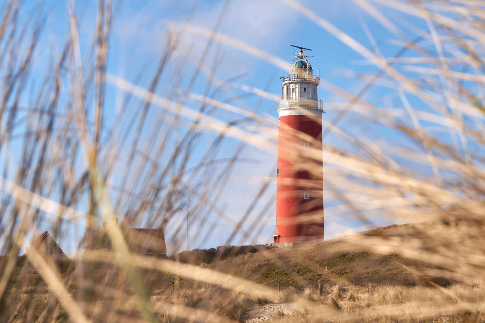 Rode vuurtoren tussen het helmgras door.