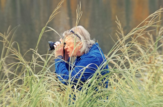 Vrouw met fototoestel in het hoge gras