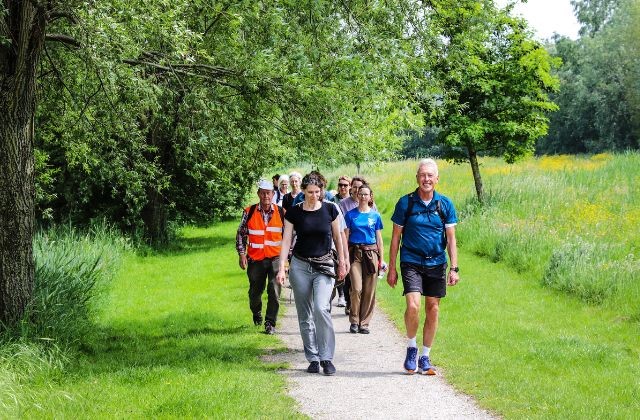 Groep deelnemers aan een wandeltrai9ning loopt op een pad