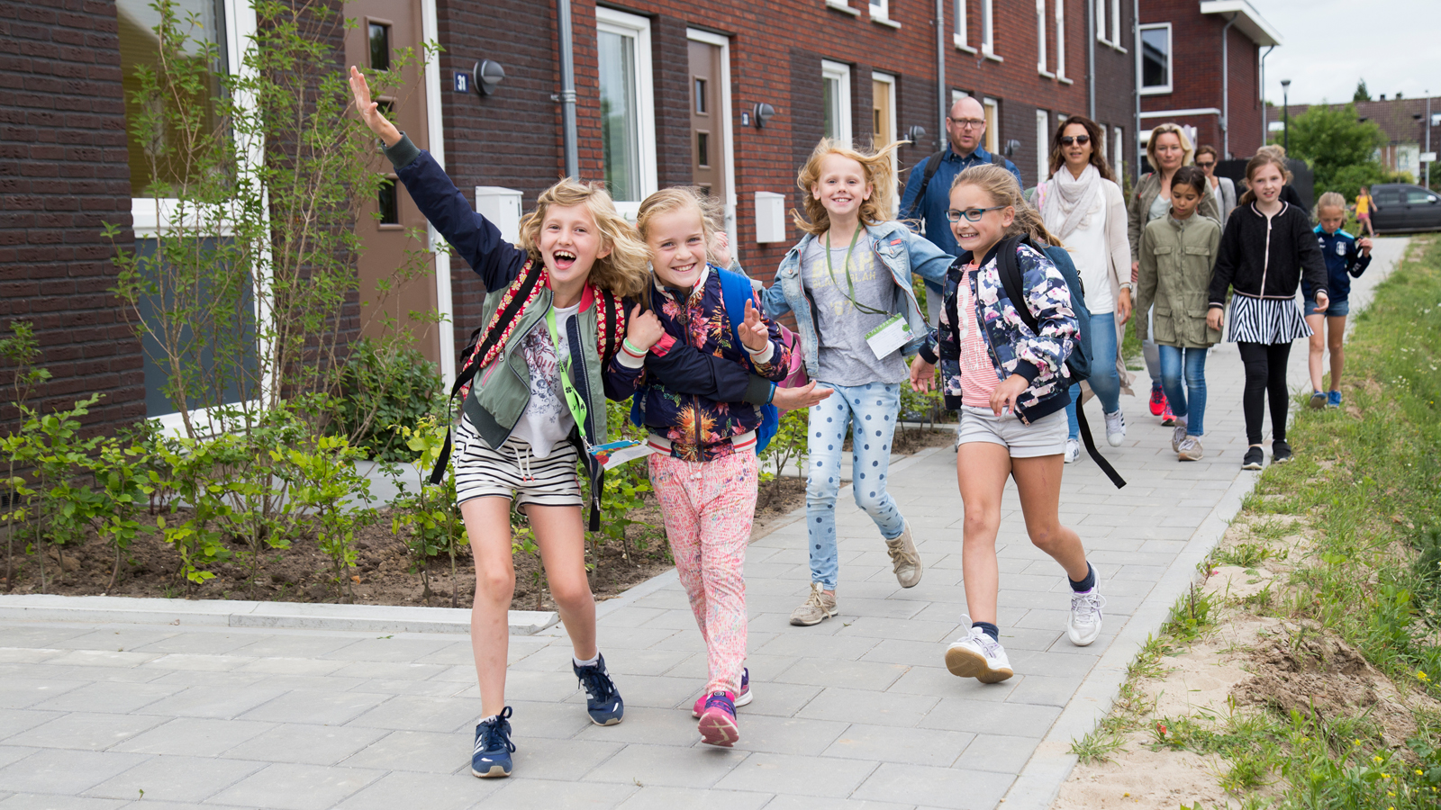 Vrolijke kinderen op straat die de Avond4daagse lopen