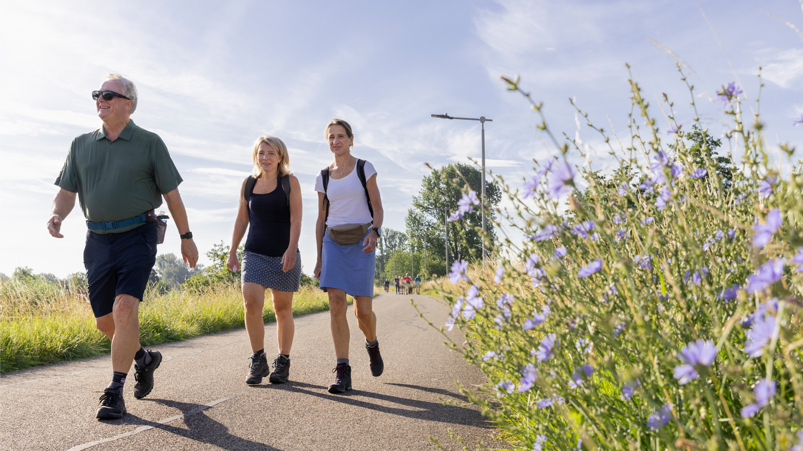 Man en twee vrouwen wandelen op een weg