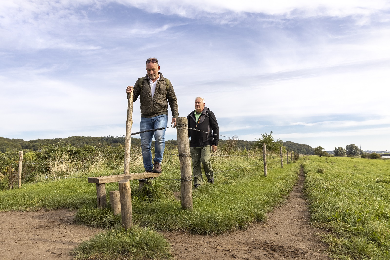 Wandelaars mannen bij overstapje in weilanden