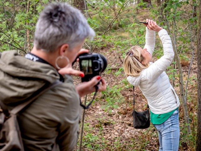 afbeelding van deelnemers aan een fotografieworkshop in de natuur.