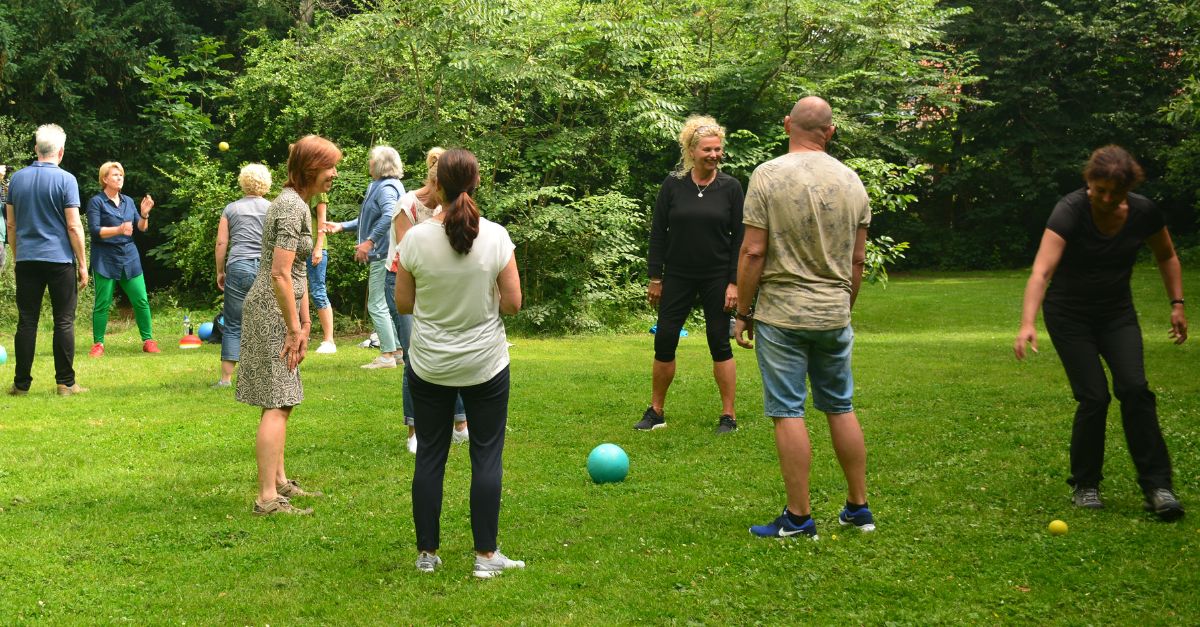 Deelnemers wandeltraining moeten lachen op een grasveld