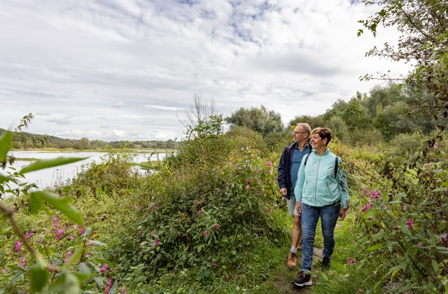 Man en vrouw wandelen langs een rivier