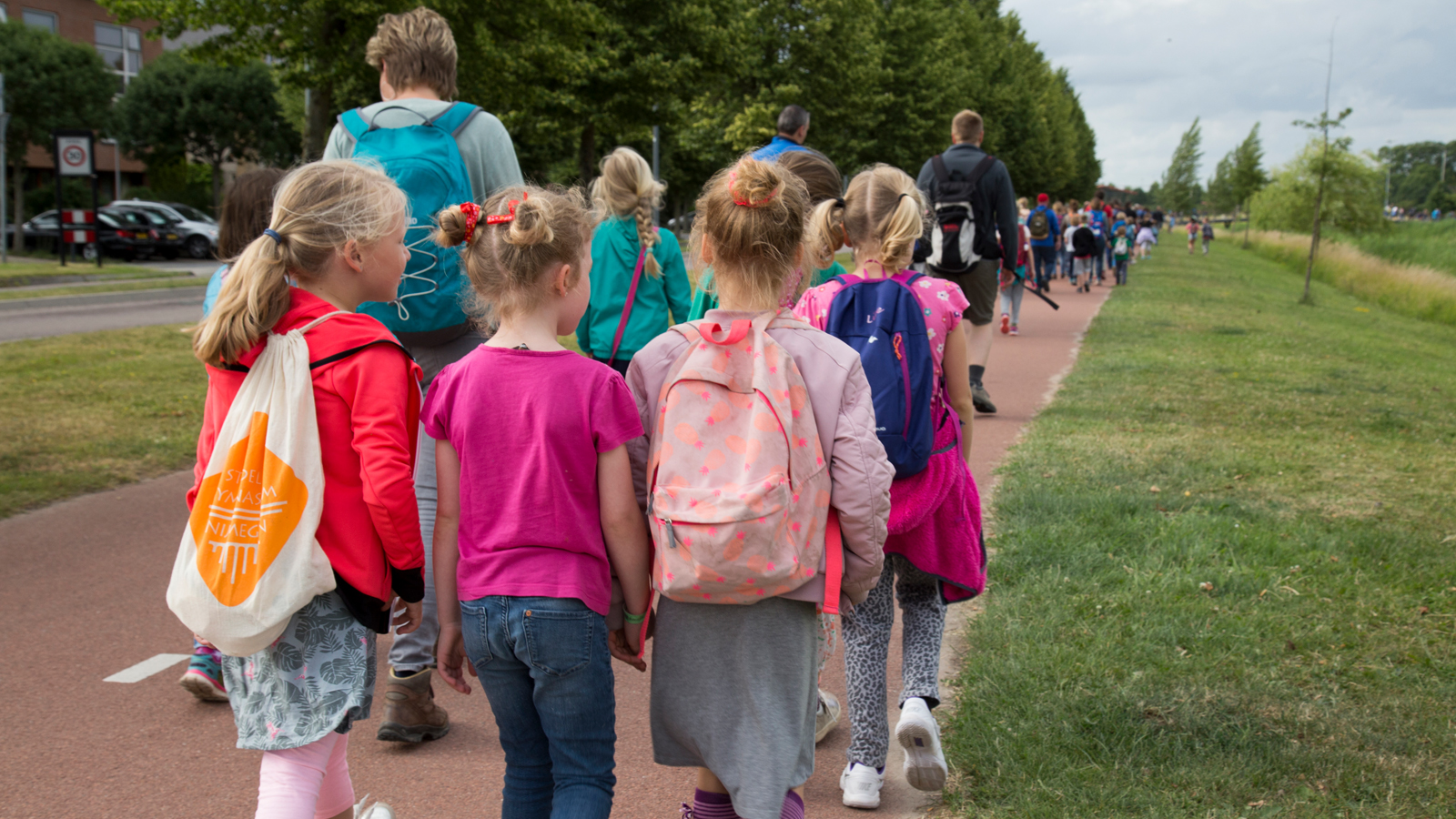 Kinderen en ouders op de rug gefotografeerd tijdens de Avond4daagse