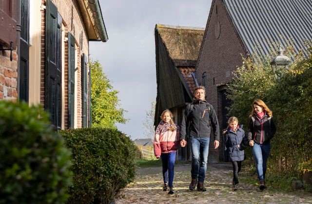 Gezin wandelt langs boerderij