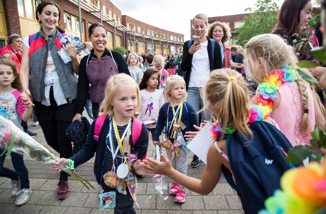 Kinderen die meelopen met de Avond4daagse Nijmegen-Noord geven elkaar een high five.