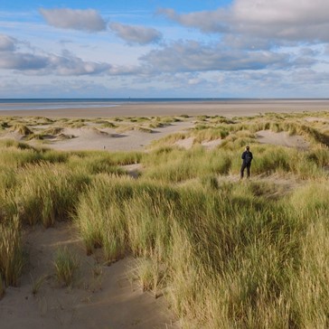 Vrouw staat in de duinen op Texel